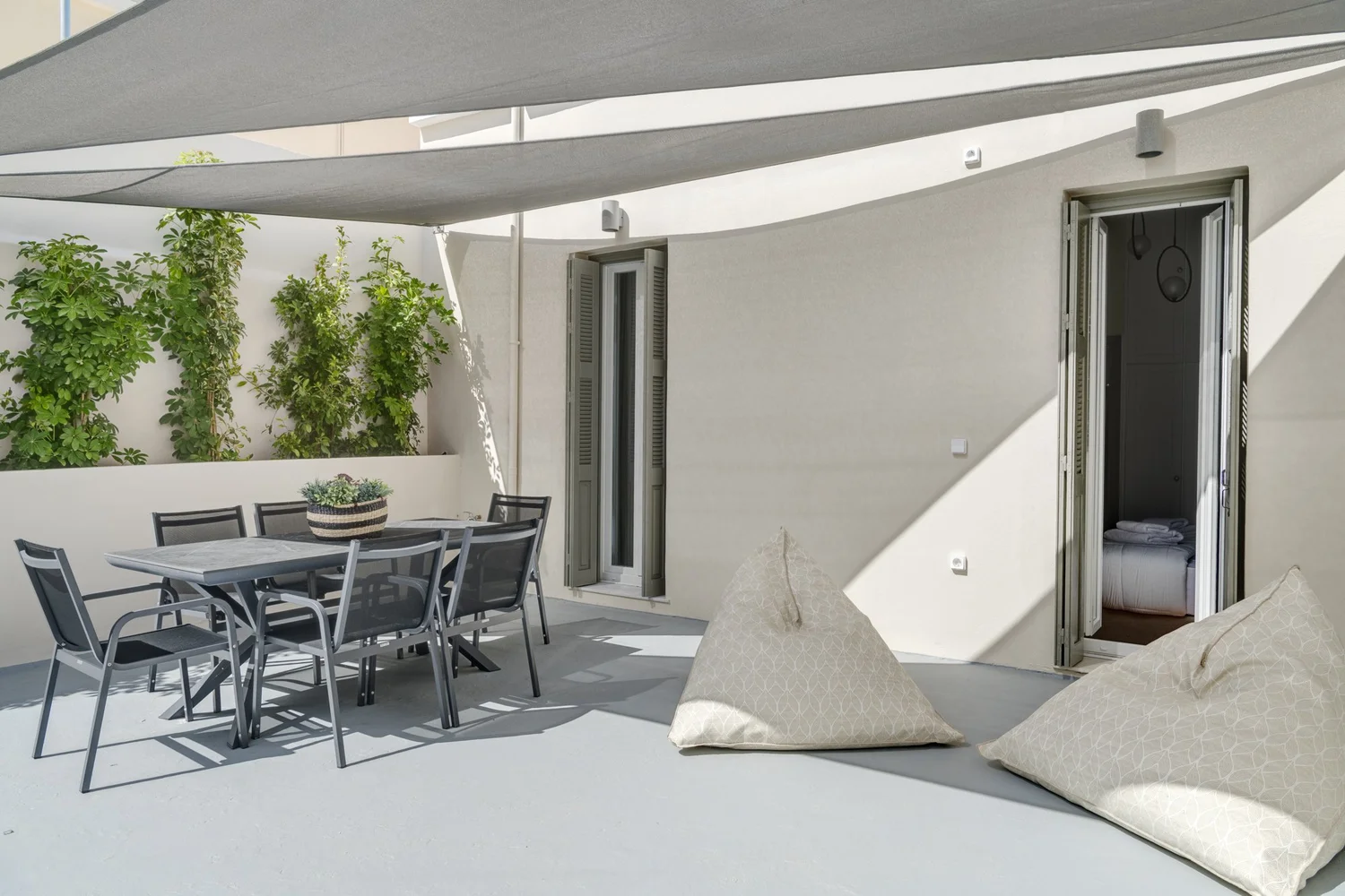 Lower terrace shared by bedrooms one and two, with dining table and plants