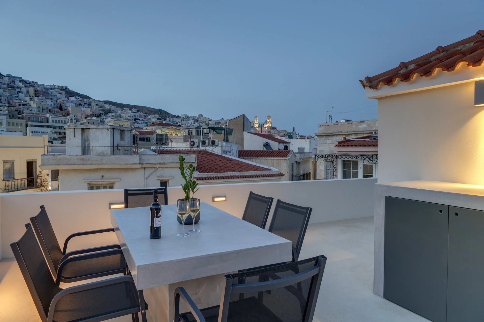 Private rooftop dining area overlooking Ermoupolis at dusk